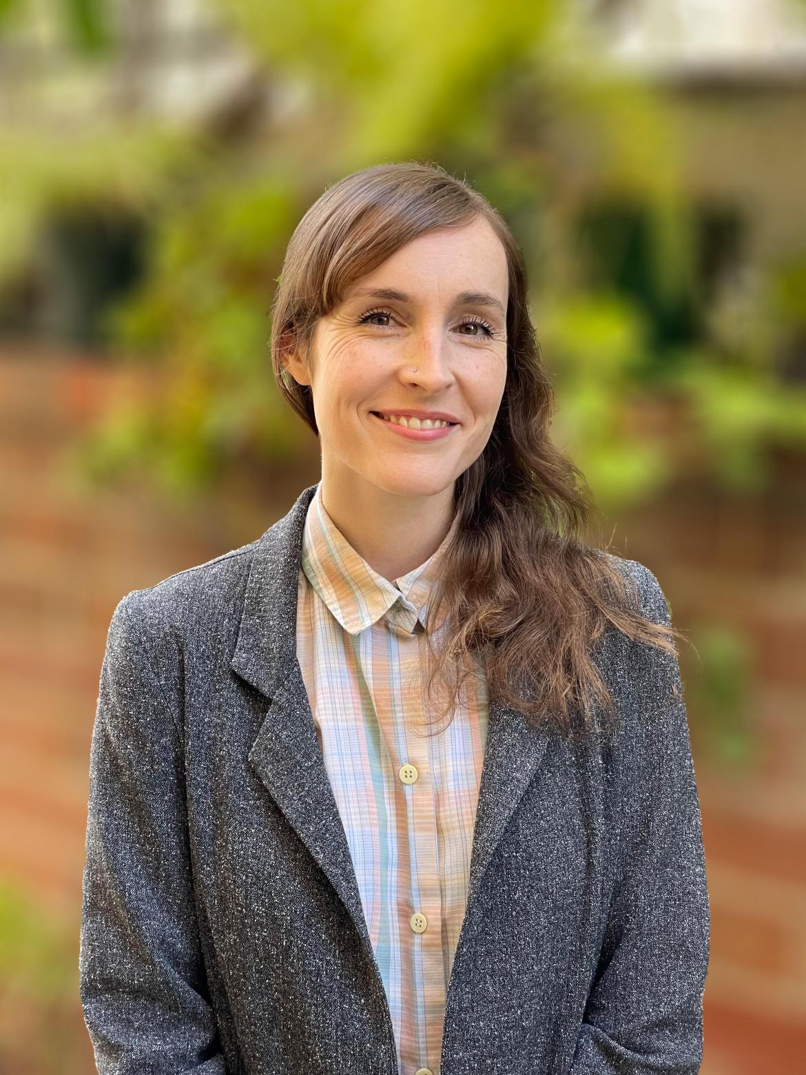 Therapist Katie Gaydos wearing a blazer and a collared shirt smiling at the camera 